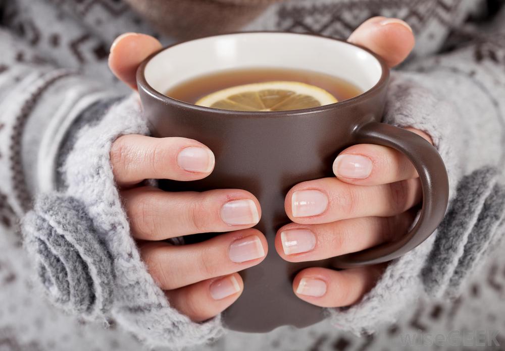 womans-hands-holding-brown-mug-of-tea